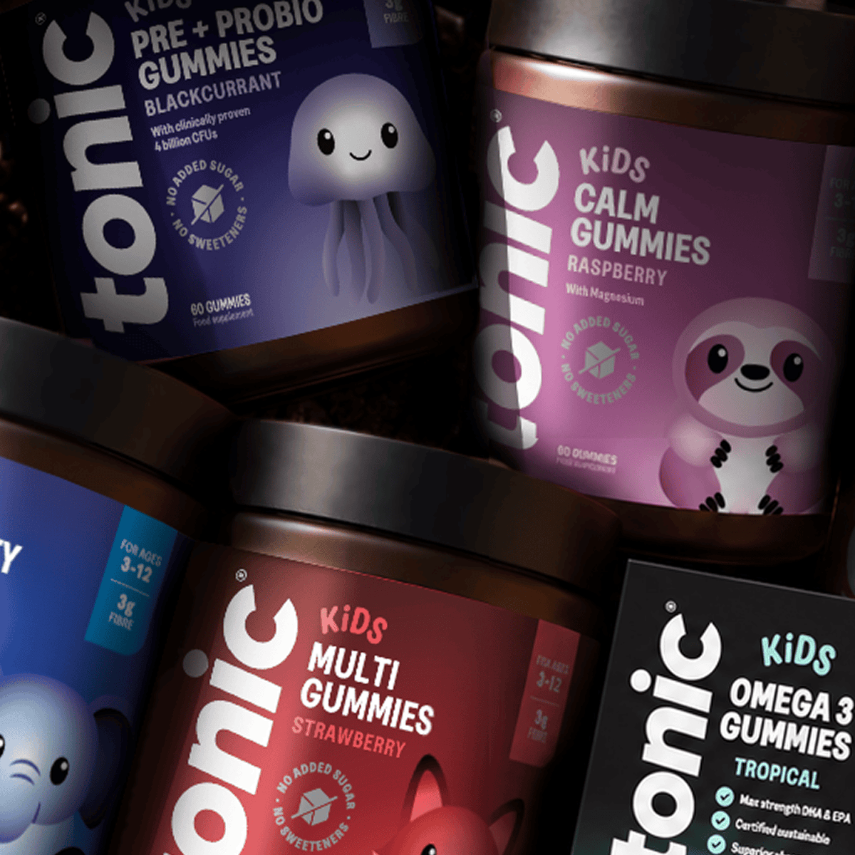 A close-up arrangement of Tonic Kids gummy supplement jars, including Pre + Probi Gummies in Blackcurrant, Calm Gummies in Raspberry, and Multi Gummies, with colorful labels and cartoon animal illustrations.