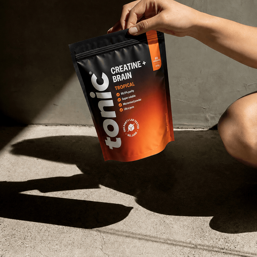 A person holding a pouch of Tonic Creatine + Brain by the top.