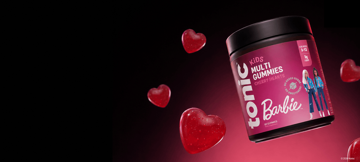 A jar of Barbie Tonic Multi Gummies floating on a dark red to black gradient background with floating red heart shapes. The jar has a black lid and a pink label featuring the Barbie logo and character graphics.