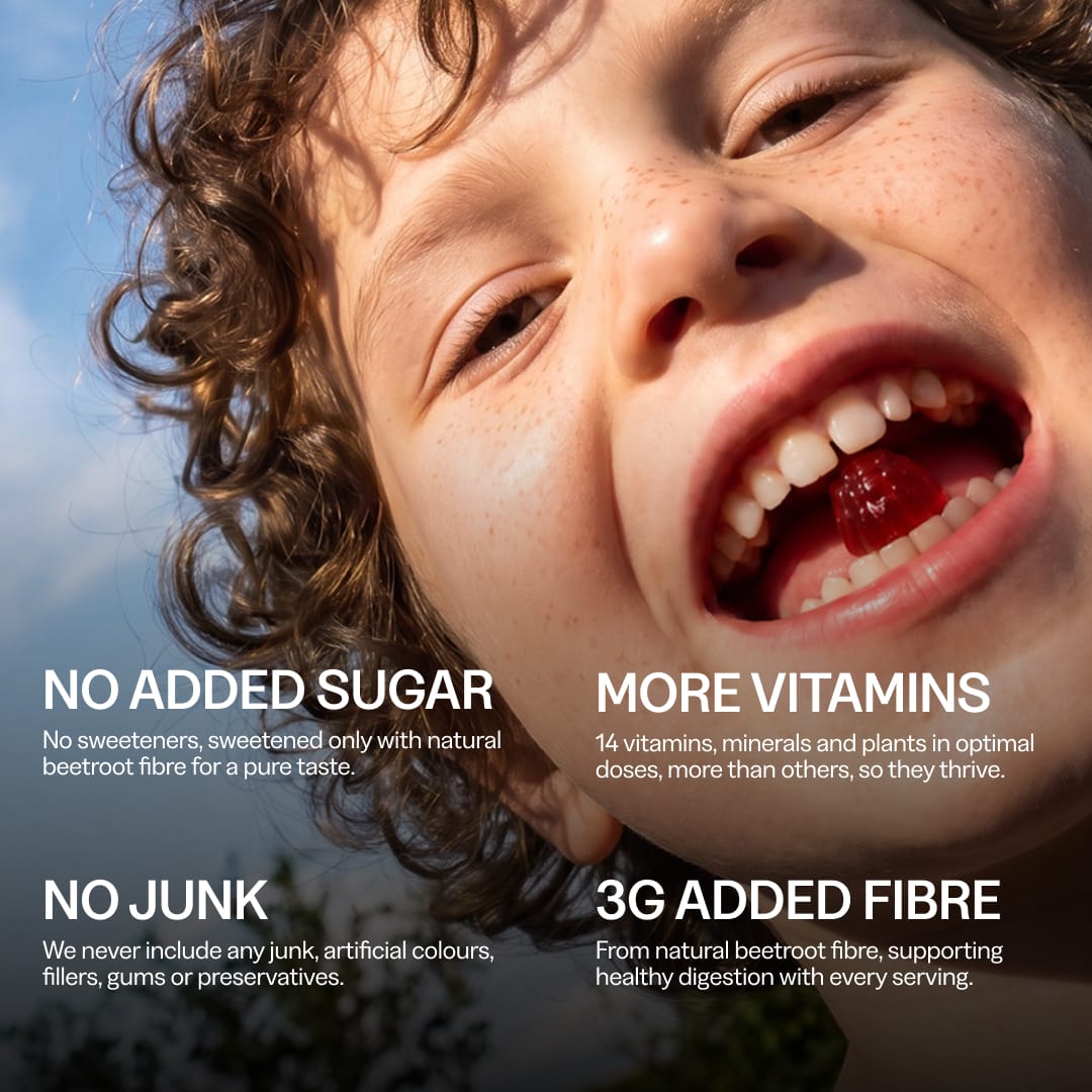 Smiling child biting a red strawberry gummy. No added sugar, sweetened with beetroot fibre; 14 vitamins, minerals and plants; no artificial colours, fillers or preservatives; 3g added fibre